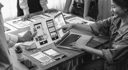 Panorama shot of front-end developer team brainstorming UI and UX designs for mobile app on paper wireframe interface. User interface development team planning for user-friendly UI design. Scrutinize